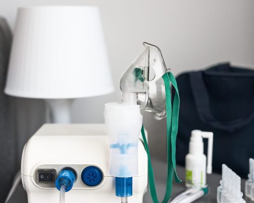 Nebuliser with breathing mask and medicines on bedside table Nebuliser with breathing mask and medicines on bedside table